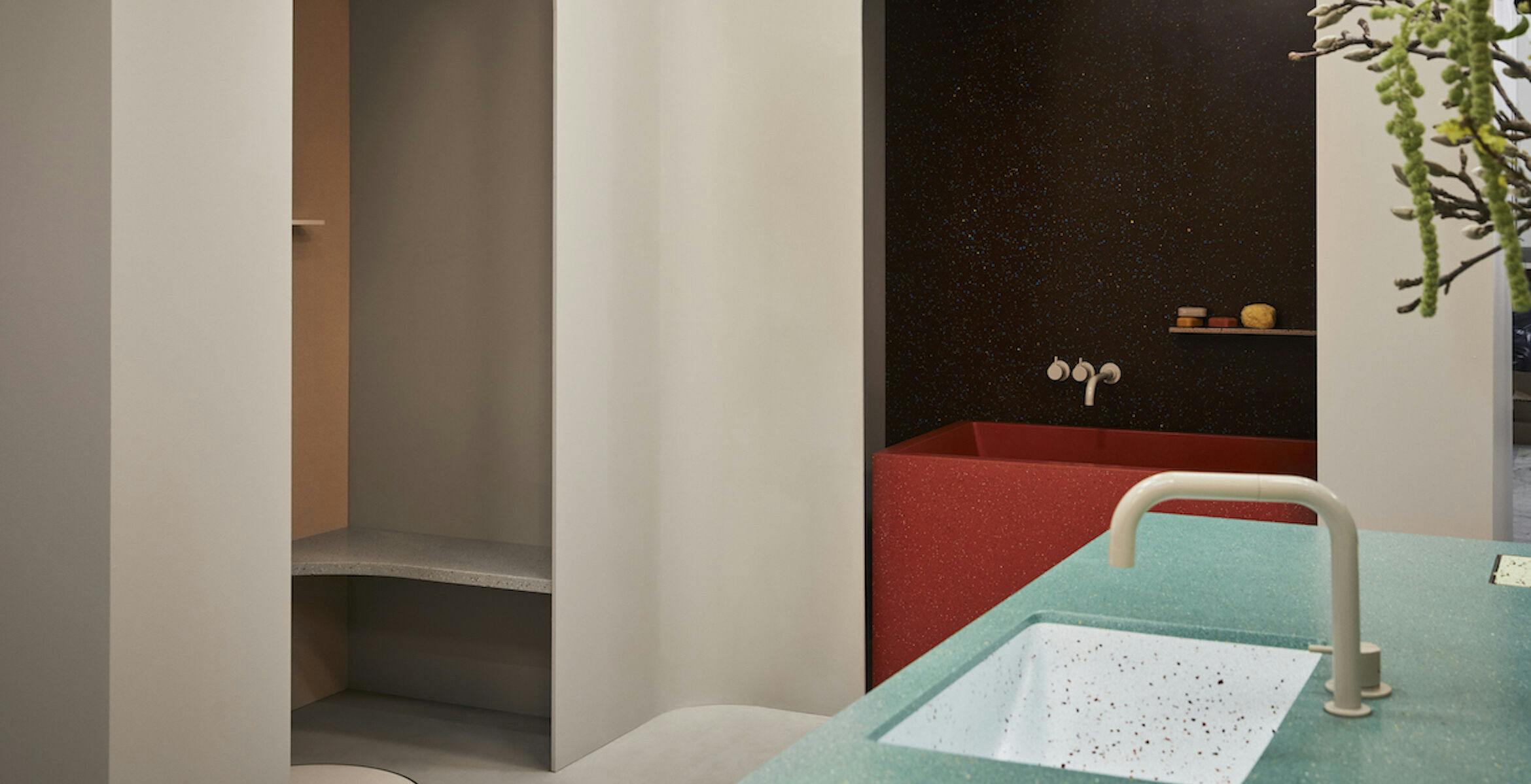 Durat showroom display showing shower seat, bathroom shelves, cast bathtub, kitchen worktop and custom Palace sink